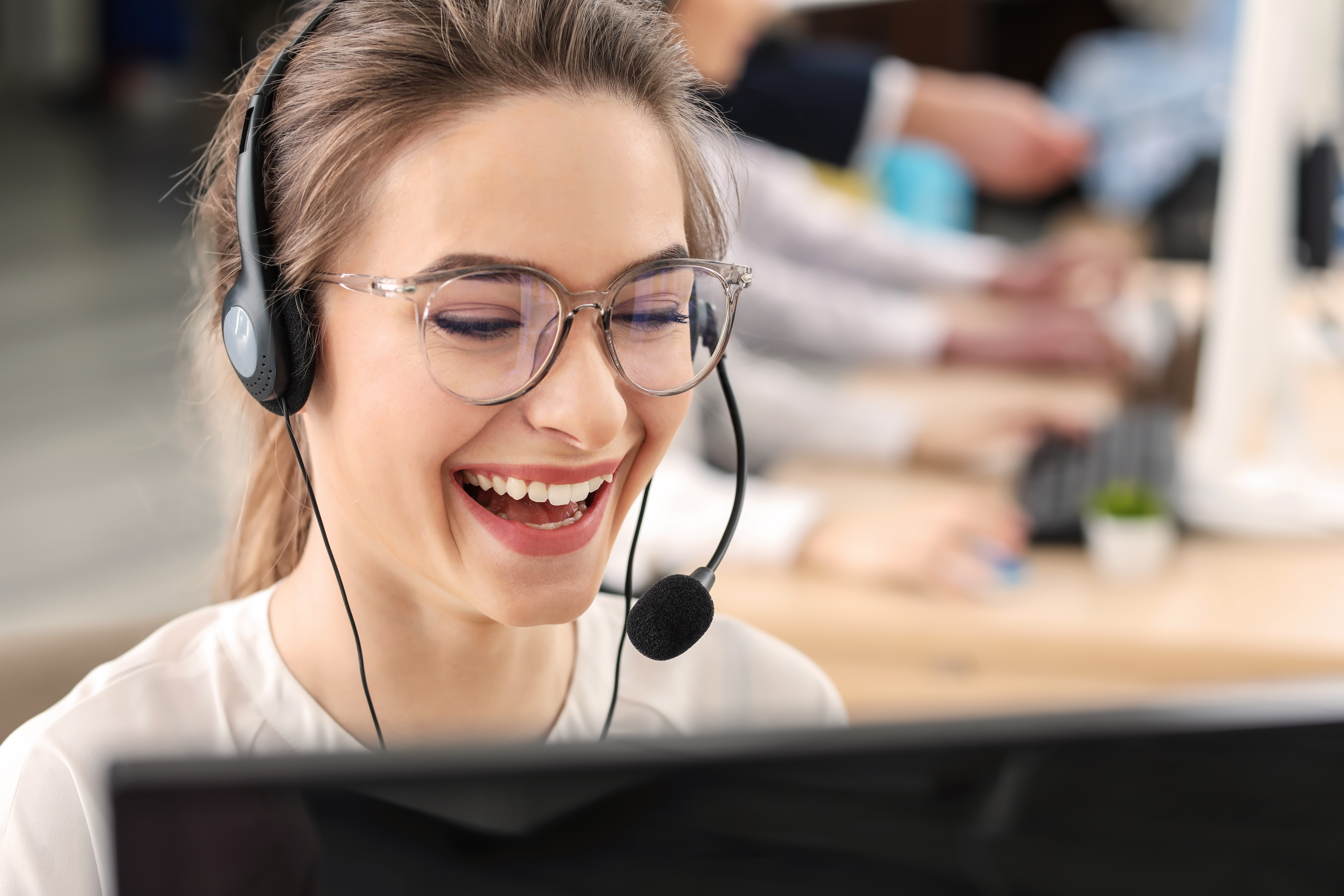 Call center agent laughing while on a call. 