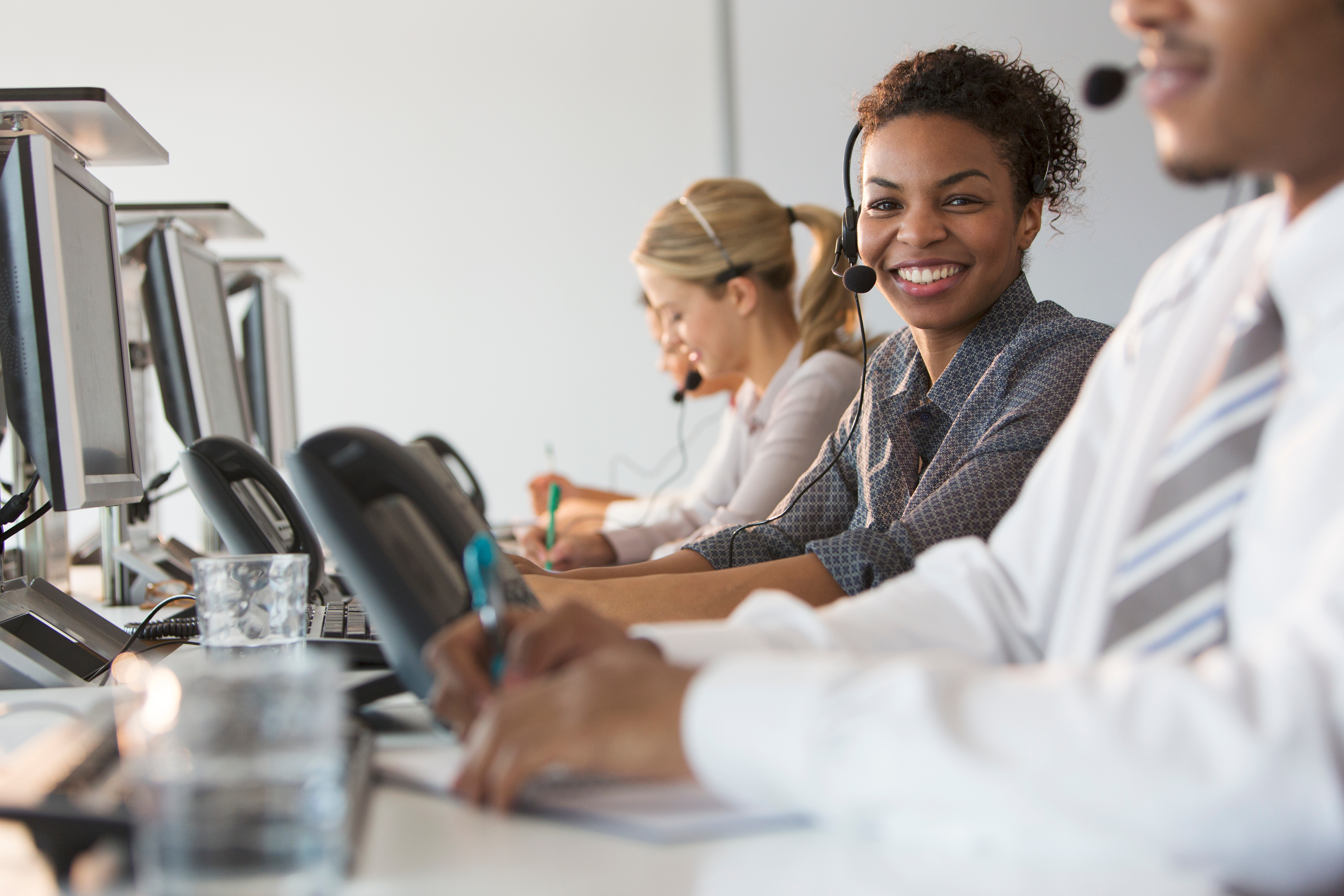 A contact center agent smiling at their workstation.