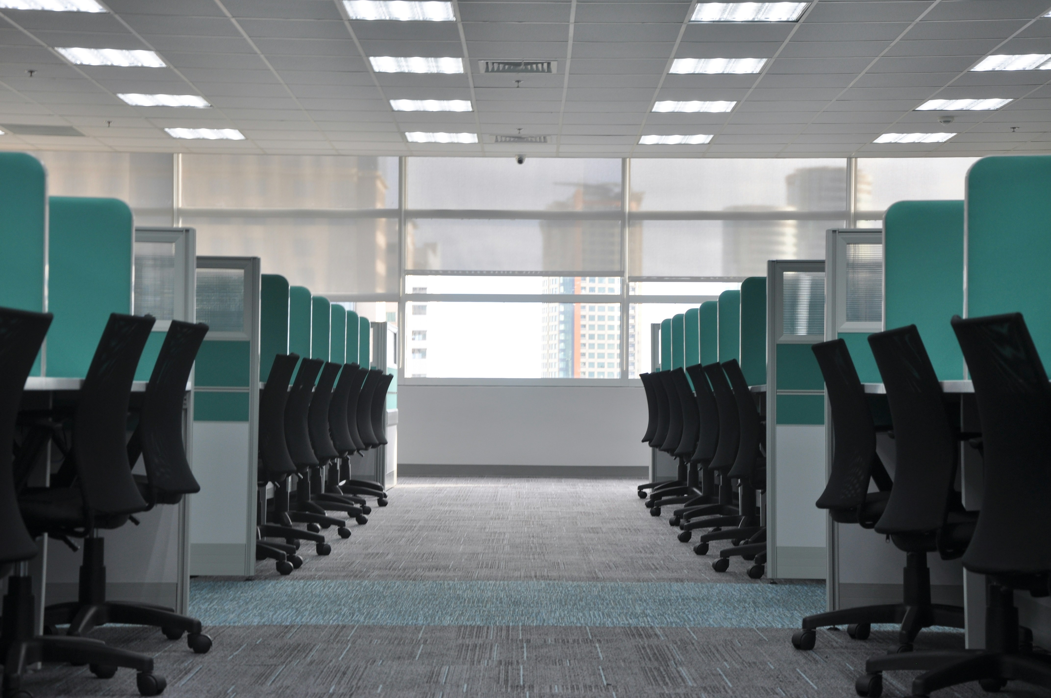 Empty office chairs sitting at call center agents workstations, image by Kate Sade